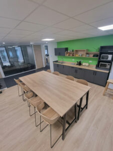 Salle de pause avec cuisine et une grande table pour manger